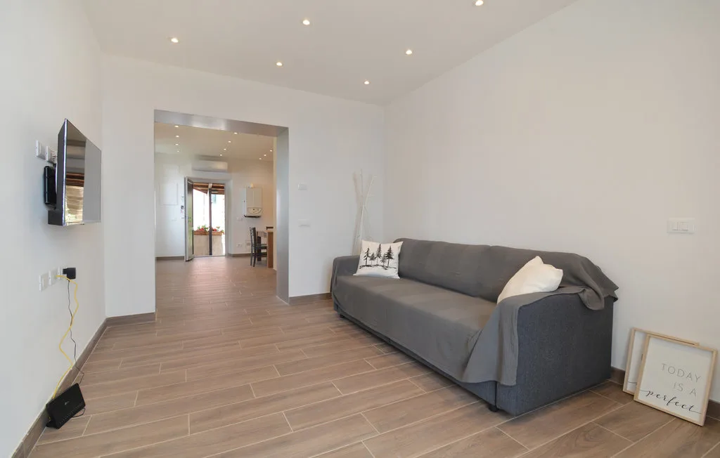 A bright living room with gray seating and a wood-look floor.