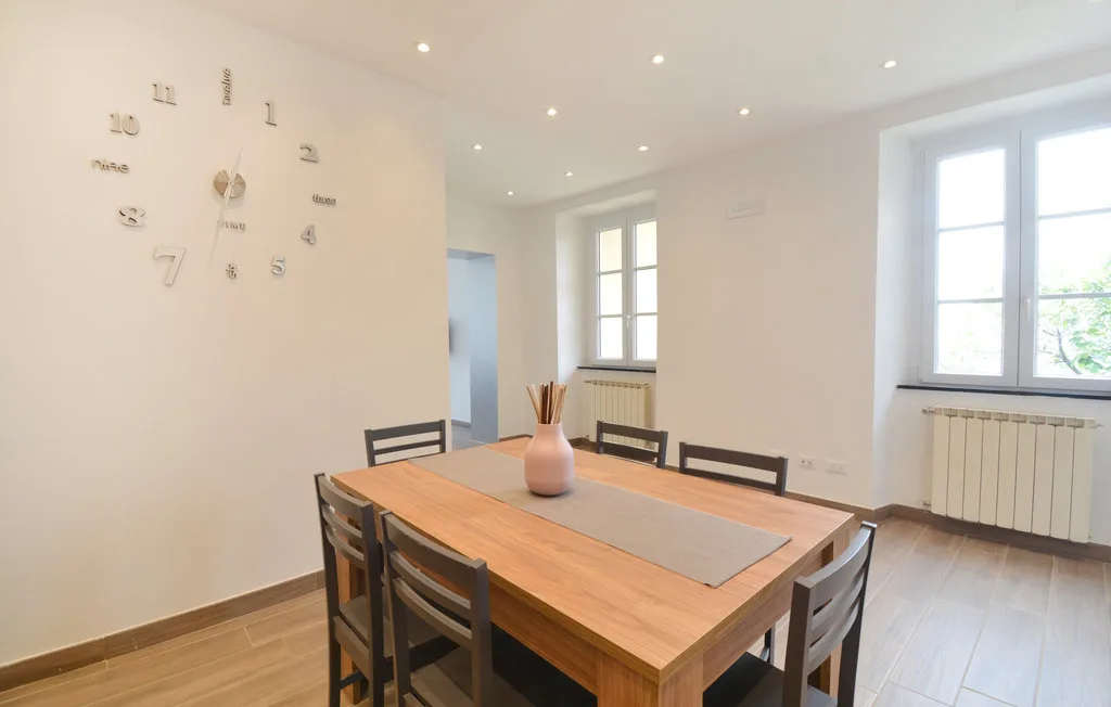 A bright dining area with a long wooden table and large windows.