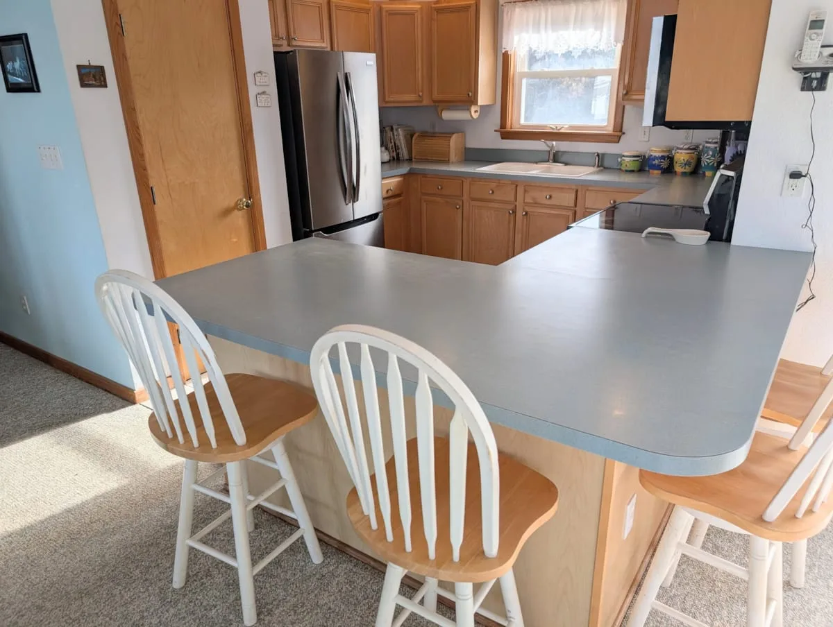 Una cocina con una isla grande y gabinetes de madera.