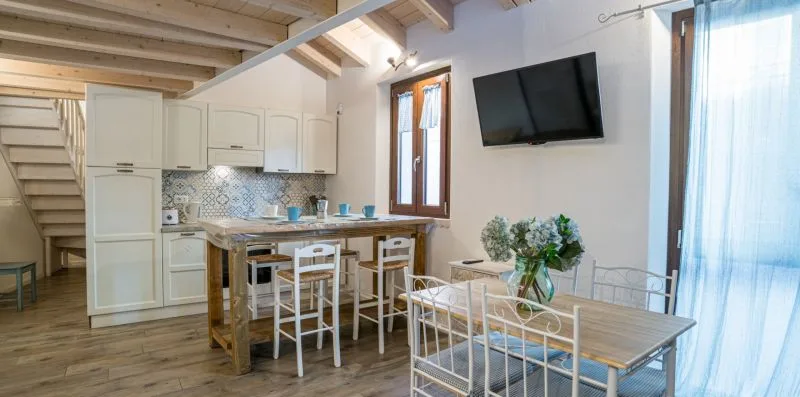 Una luminosa estancia diáfana combina una cocina compacta, comedor y cama bajo vigas vistas.