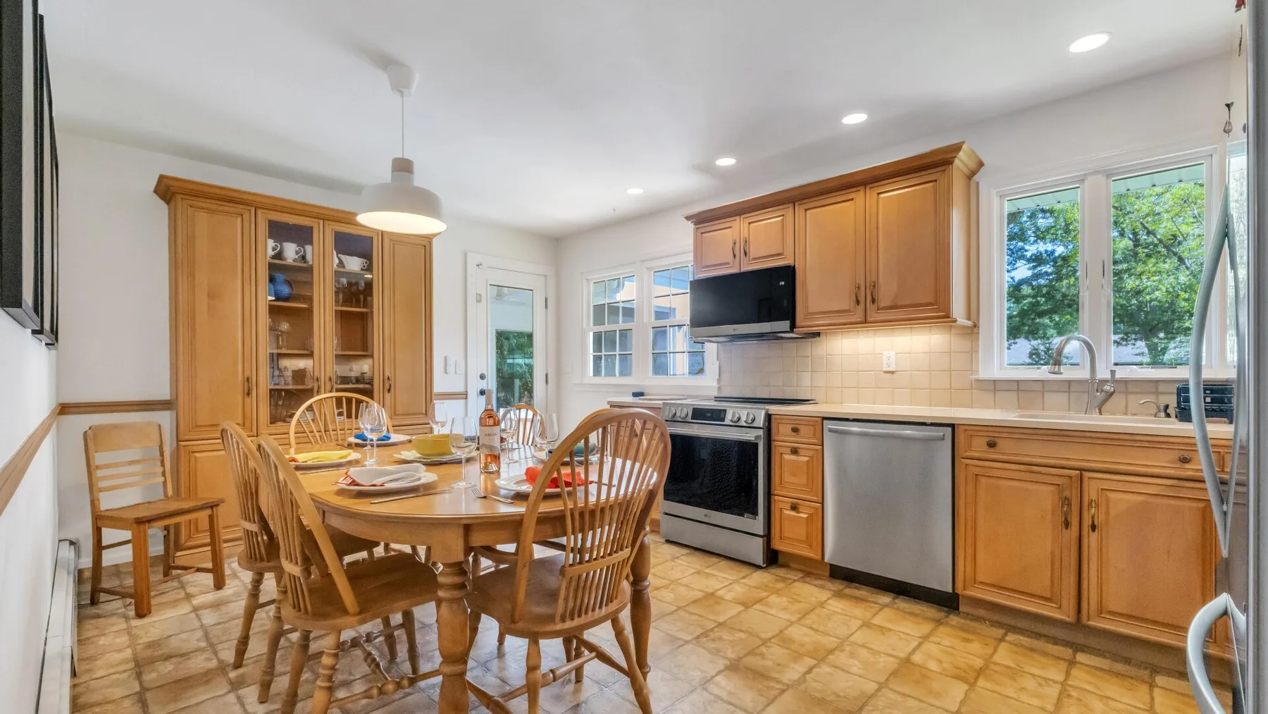 A bright kitchen and dining area with wooden cabinetry and a table.