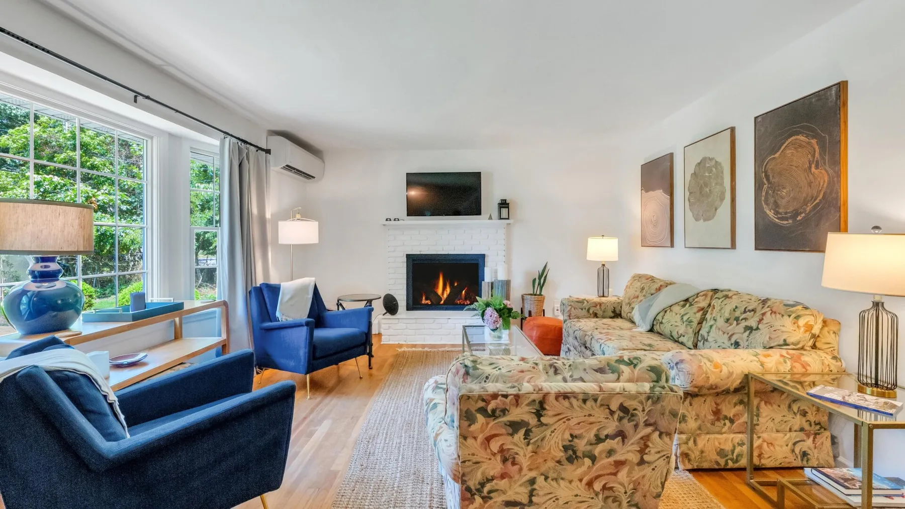 Una sala de estar con asientos dispuestos alrededor de una chimenea y un televisor.