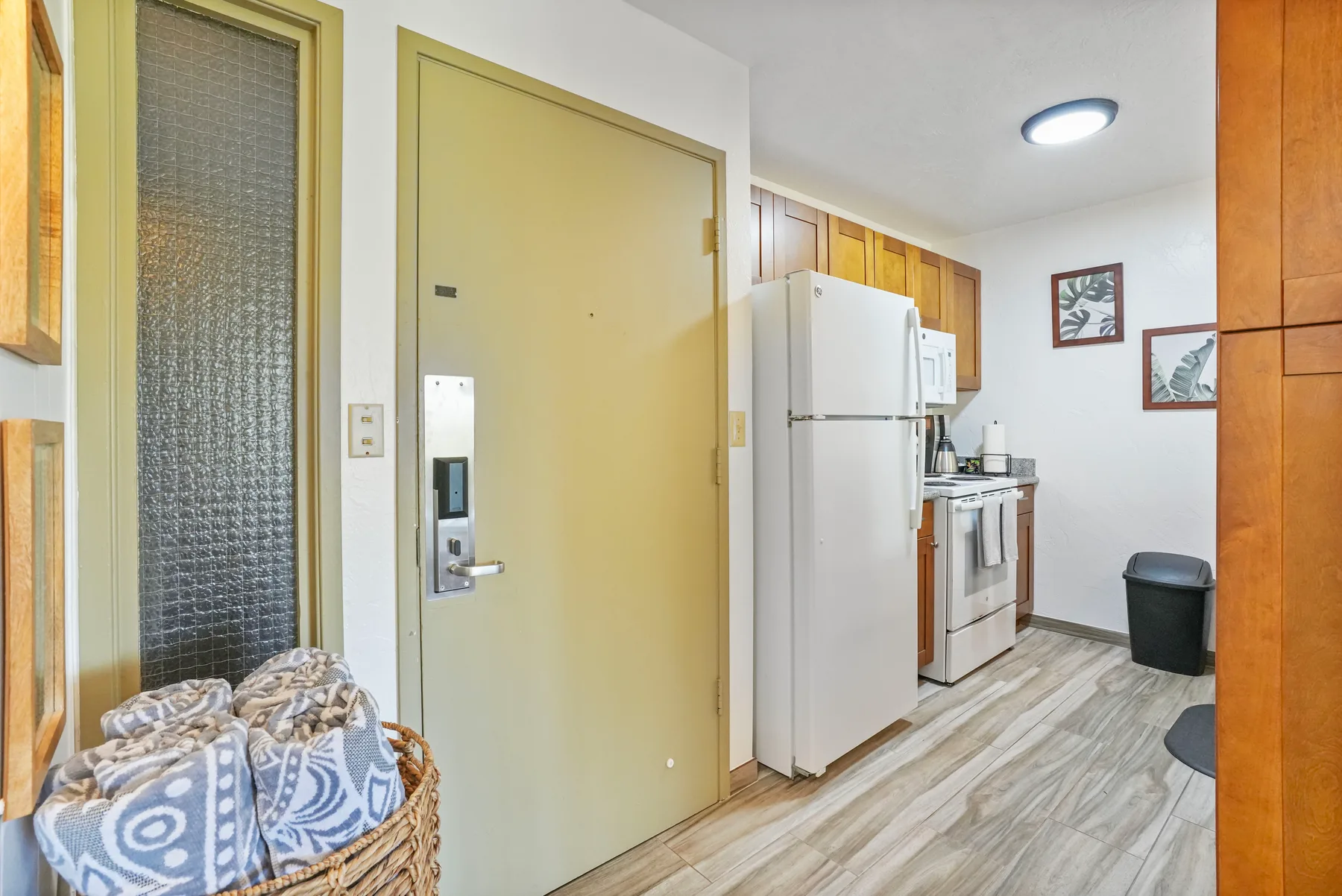 Una cocina compacta con refrigerador, estufa y gabinetes de madera.