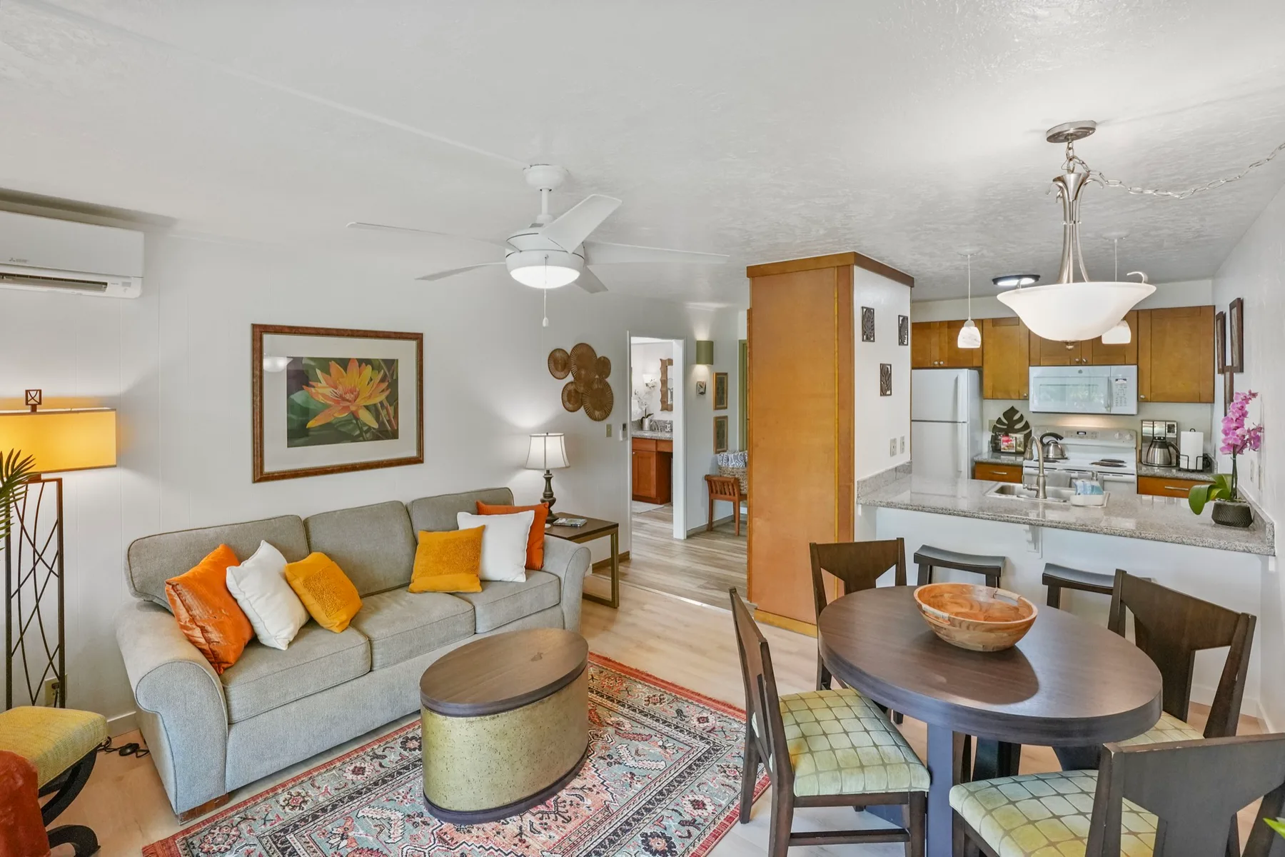 Una sala de estar y comedor integrados se abren a una cocina, con sofá y mesa de comedor.