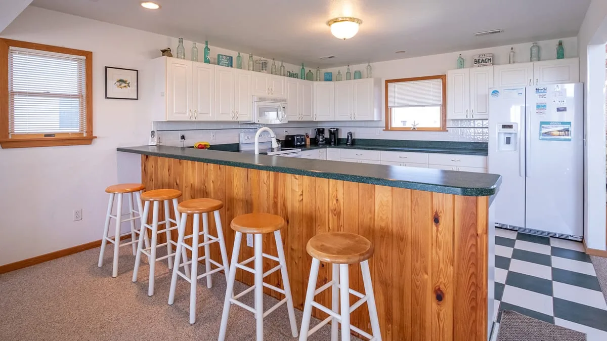 Una cocina amplia con una barra larga y taburetes.
