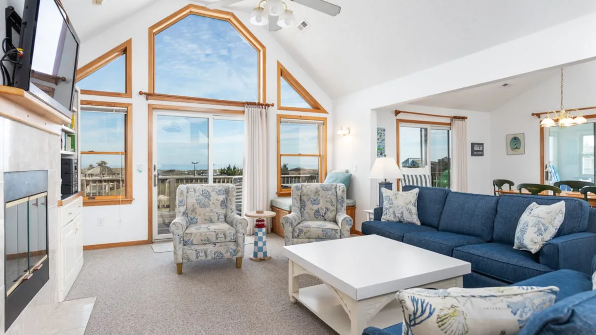 Una sala luminosa con asientos azules y ventanas altas con vistas al exterior.