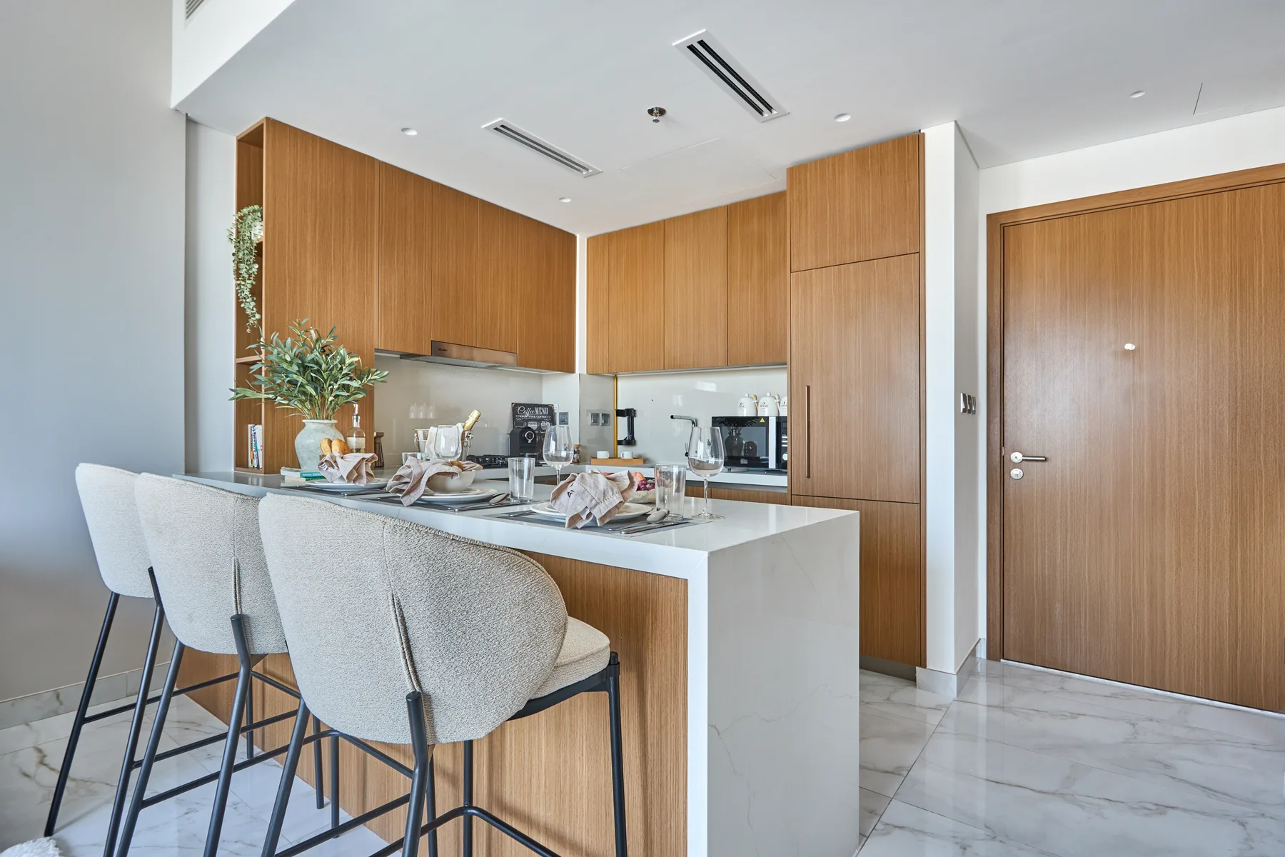 A modern kitchen and dining area with a counter and bar seating.