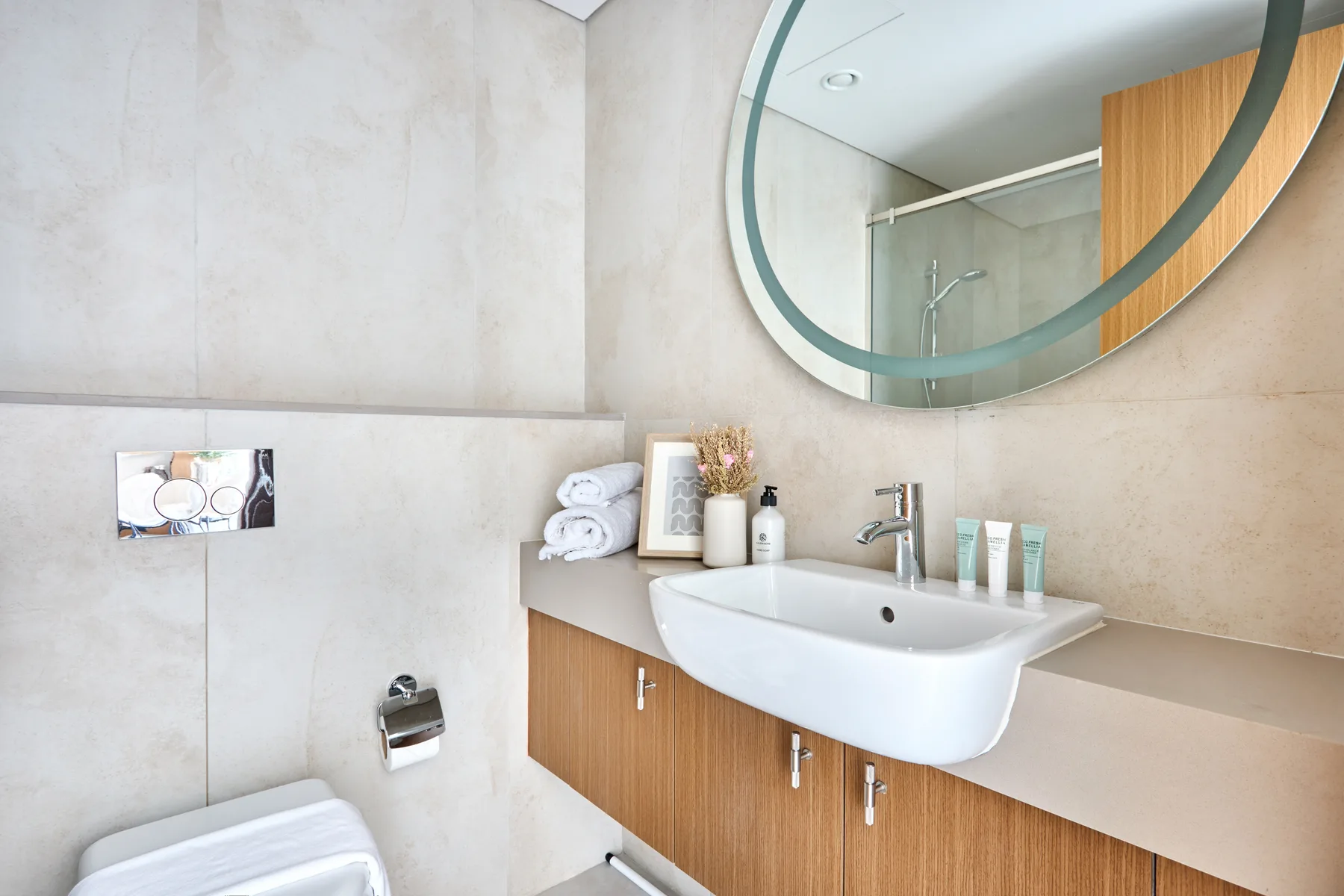 A bathroom vanity with a sink, mirror, and toiletries.