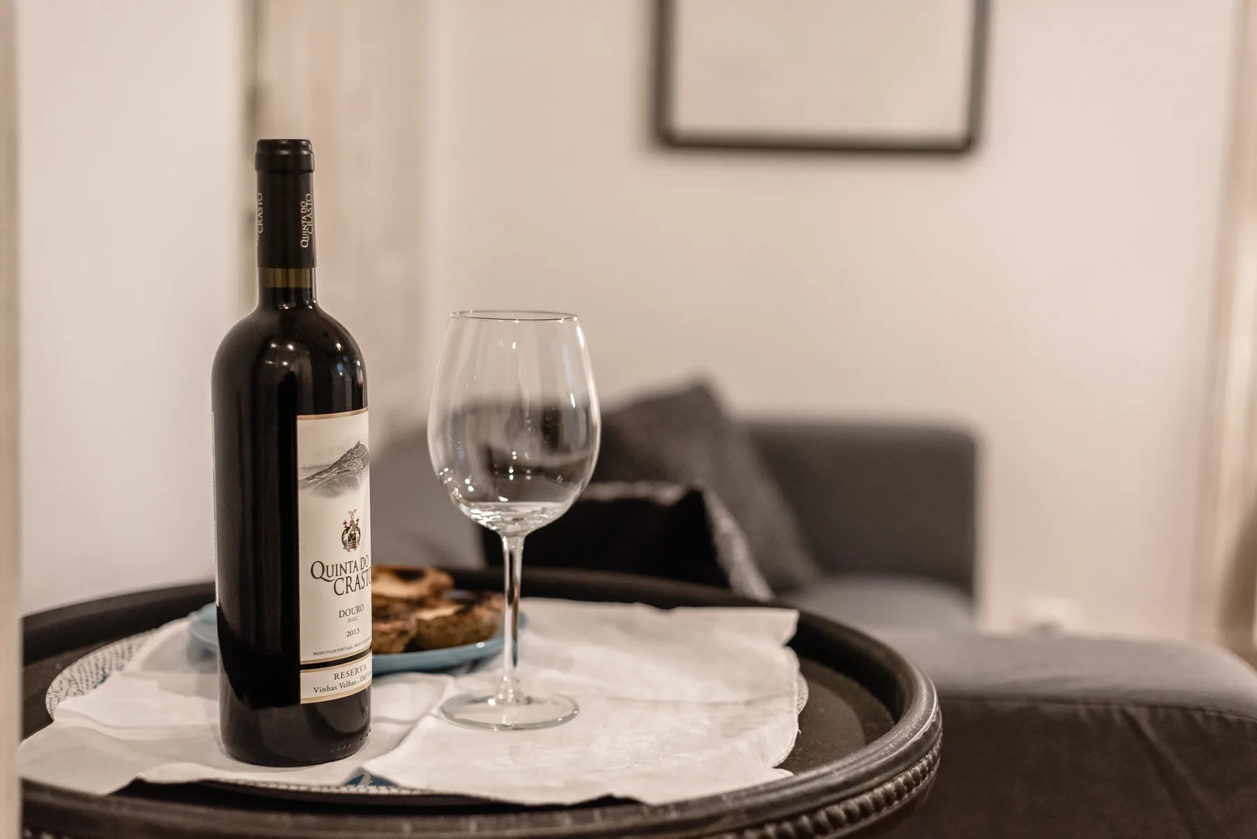 A living room seating area with a wine bottle and glass on a tray.