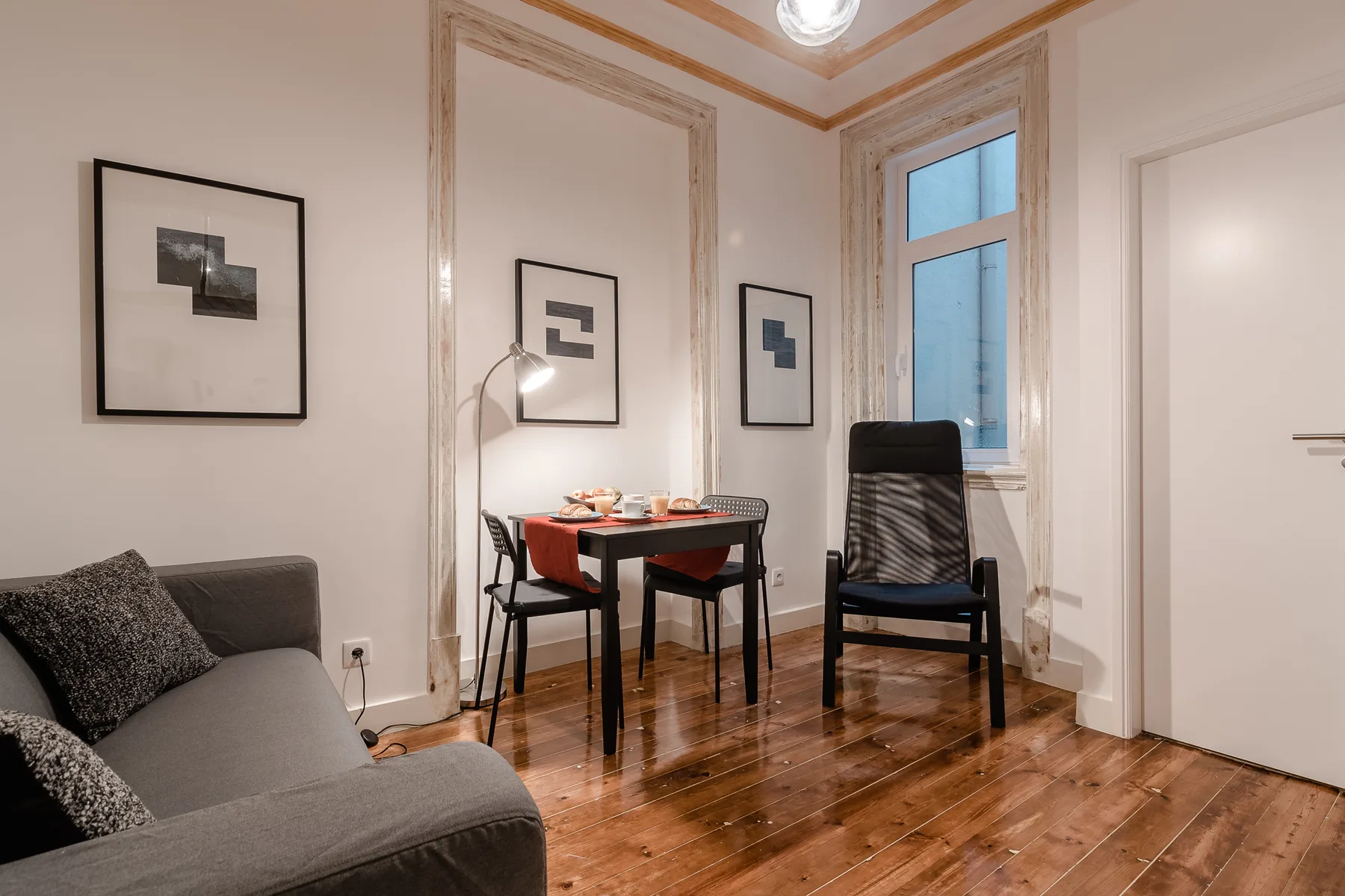 A living and dining area with a sofa, table, and chairs.