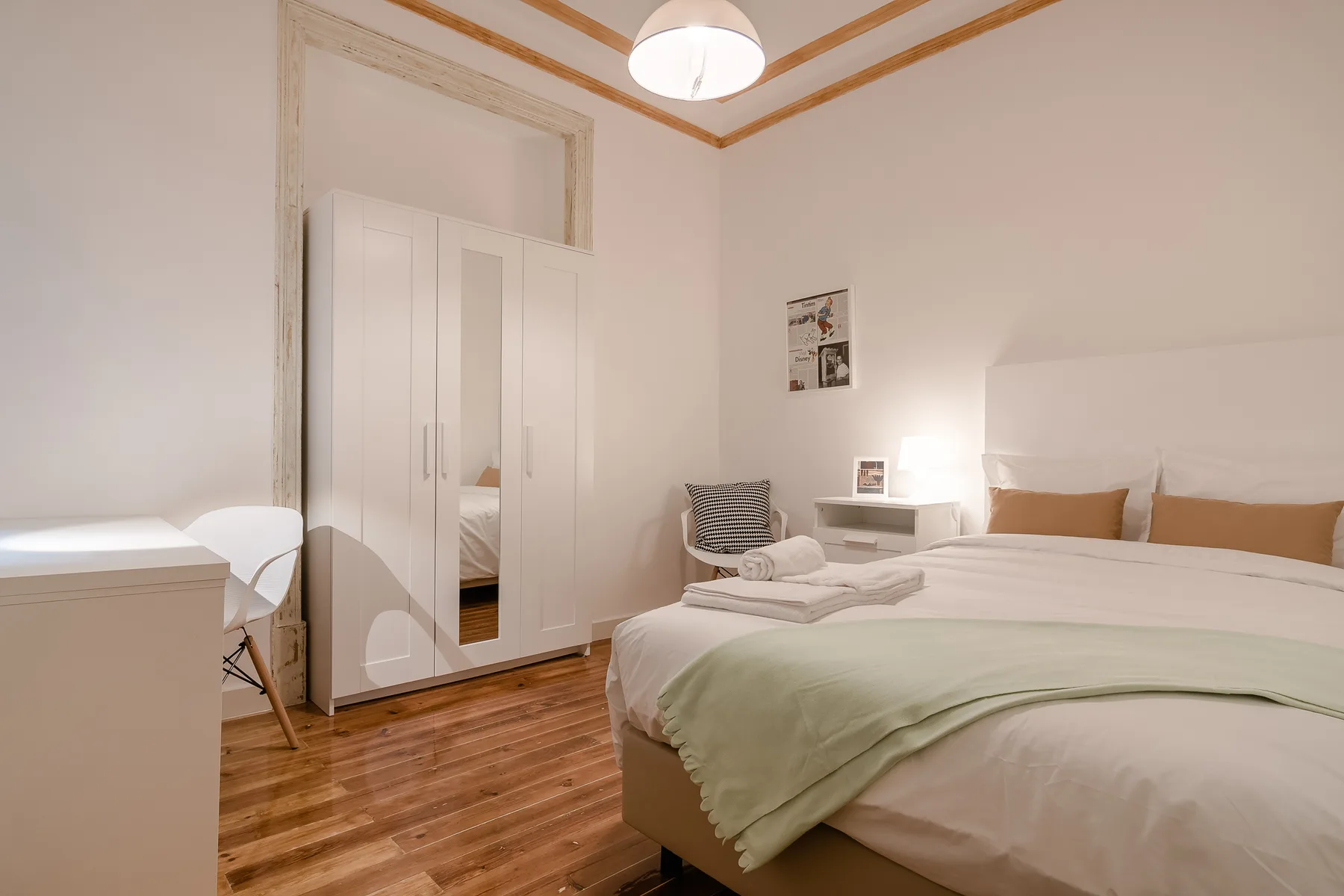 A bedroom with a bed, bedside table, and wardrobe.
