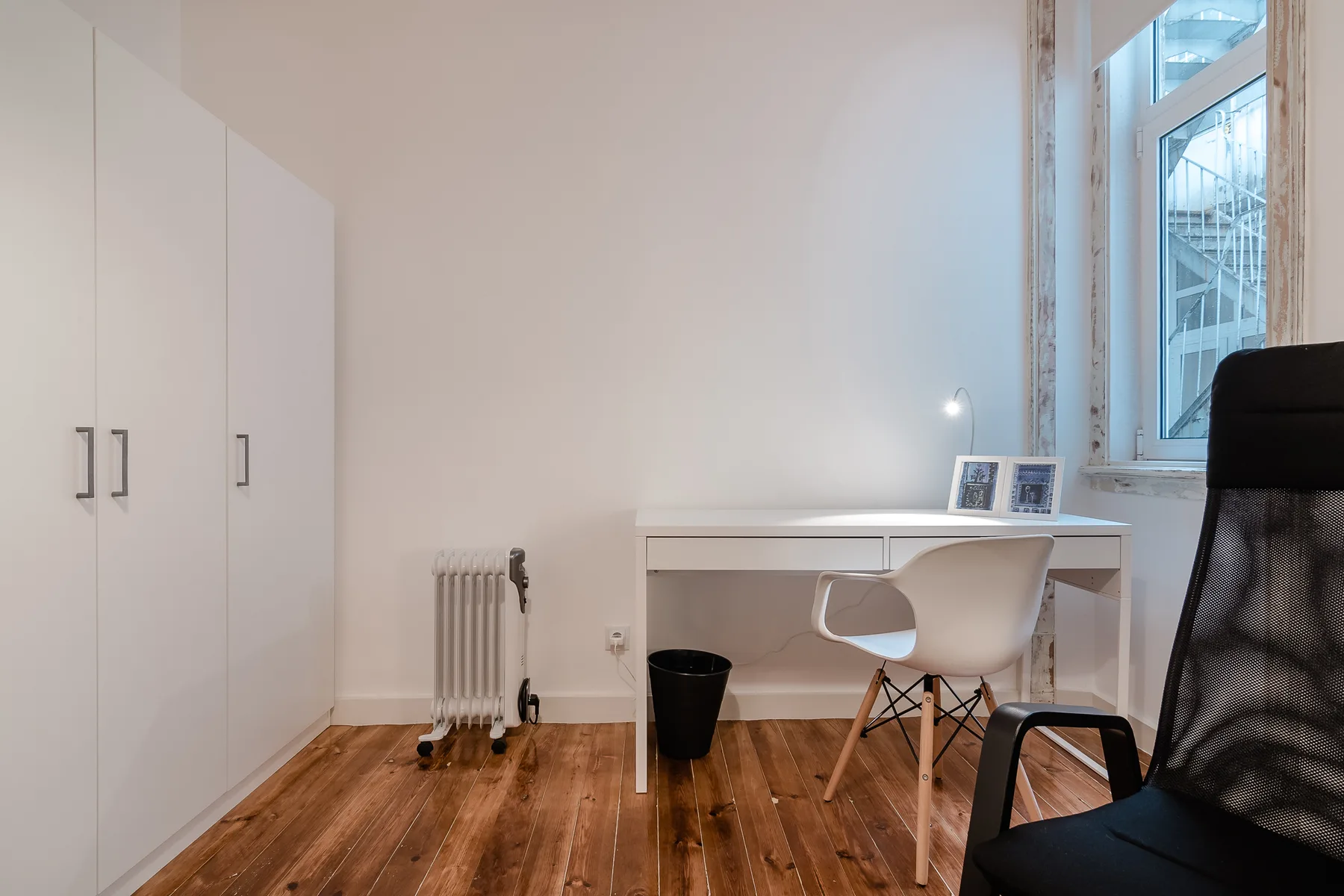 A bright workspace with a desk, seating, and a large window.