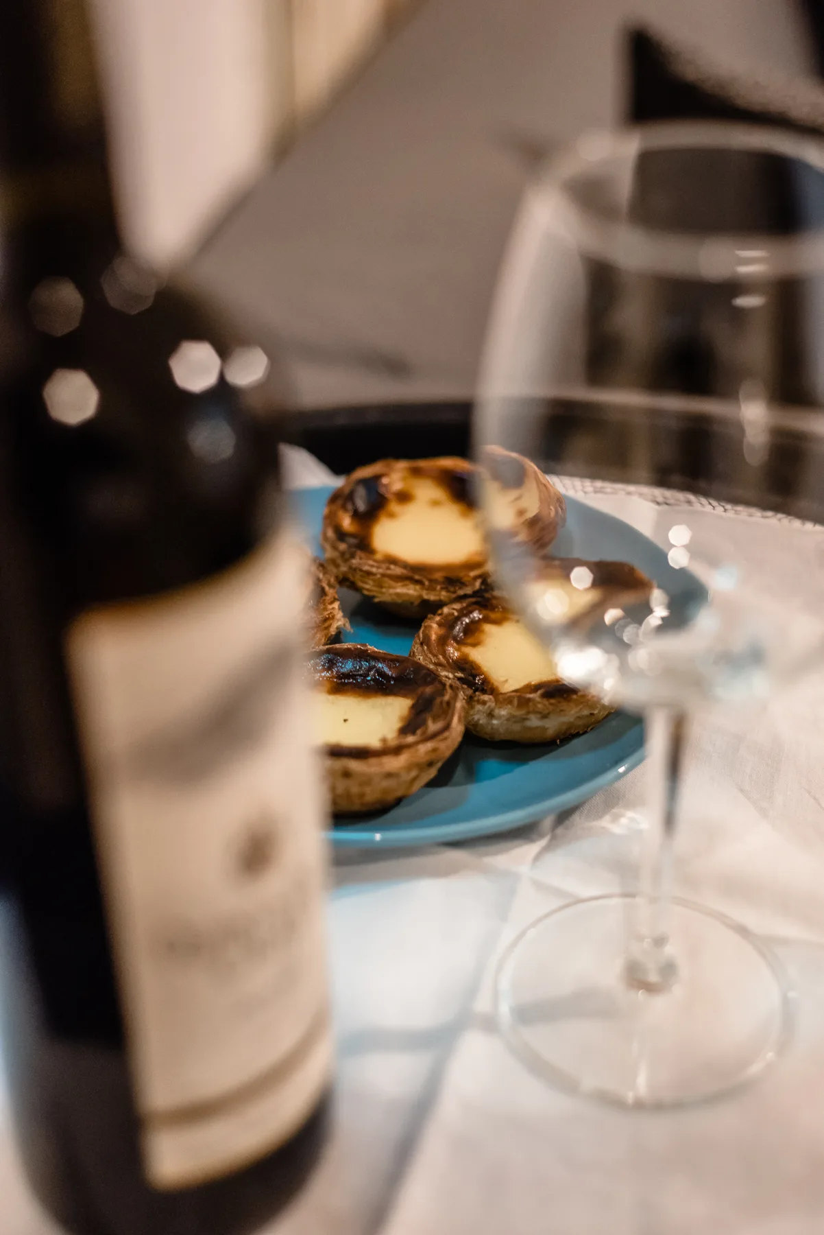 A table setting with pastries, a wine bottle, and a glass.