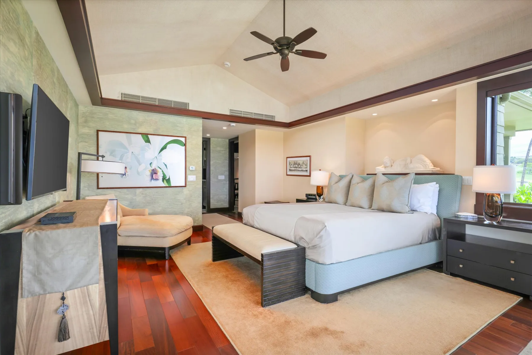 A bedroom with a large bed, bedside tables, and a television.
