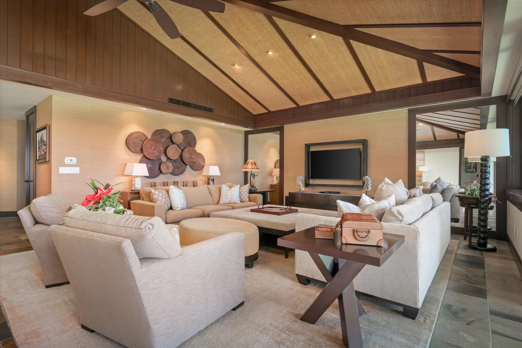 A spacious living room with light seating arranged around a coffee table.