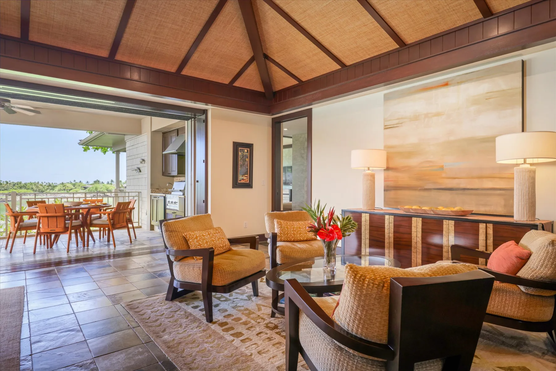A living room with seating around a low table and an open dining area beyond.