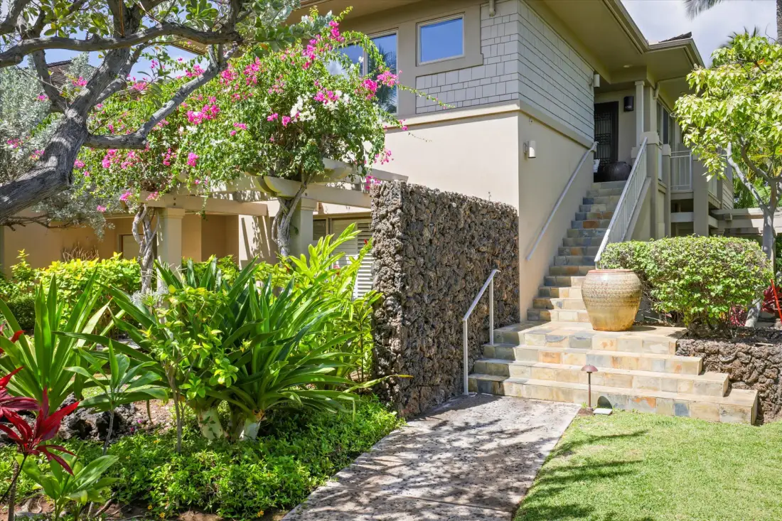 A landscaped outdoor entry with stone steps leading up to a building.