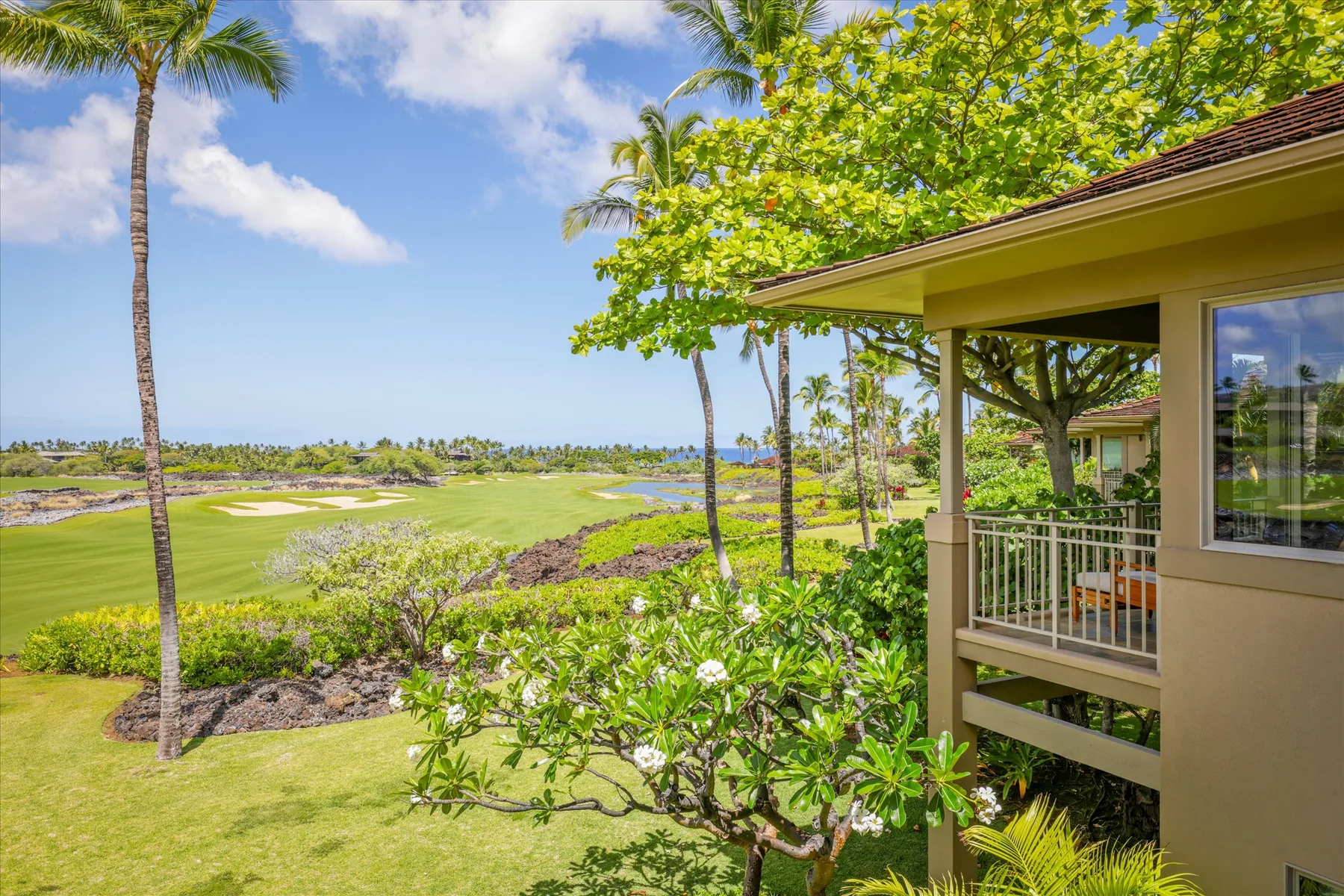 A covered patio overlooks a green golf course and landscaped grounds.