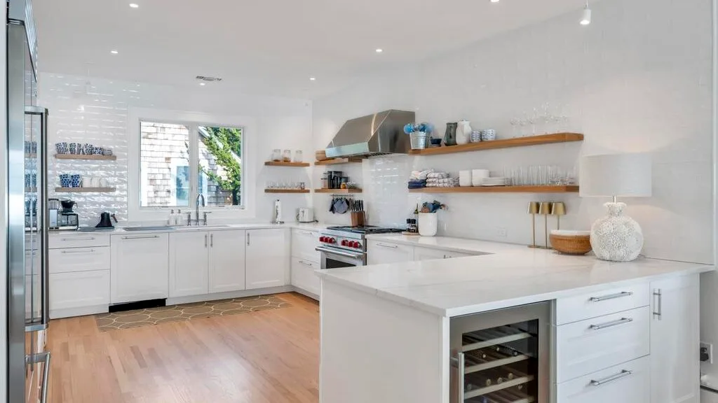 A bright kitchen with white cabinetry, a central island, and a window.