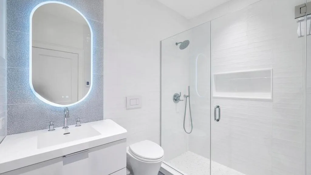A bright bathroom with a wide vanity and a glass shower.