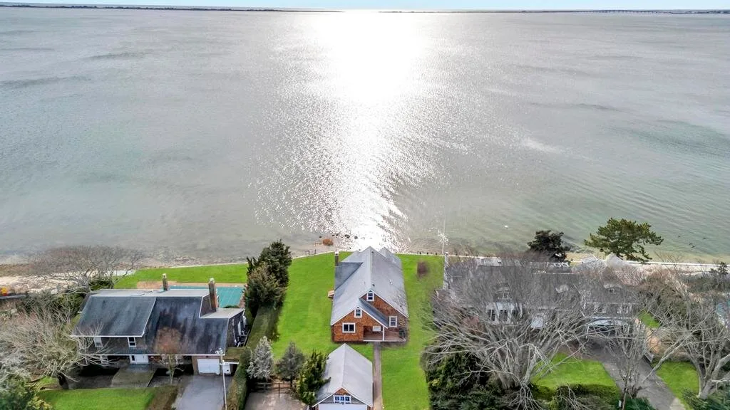 Vista aérea de casas junto al agua y una amplia extensión de agua.