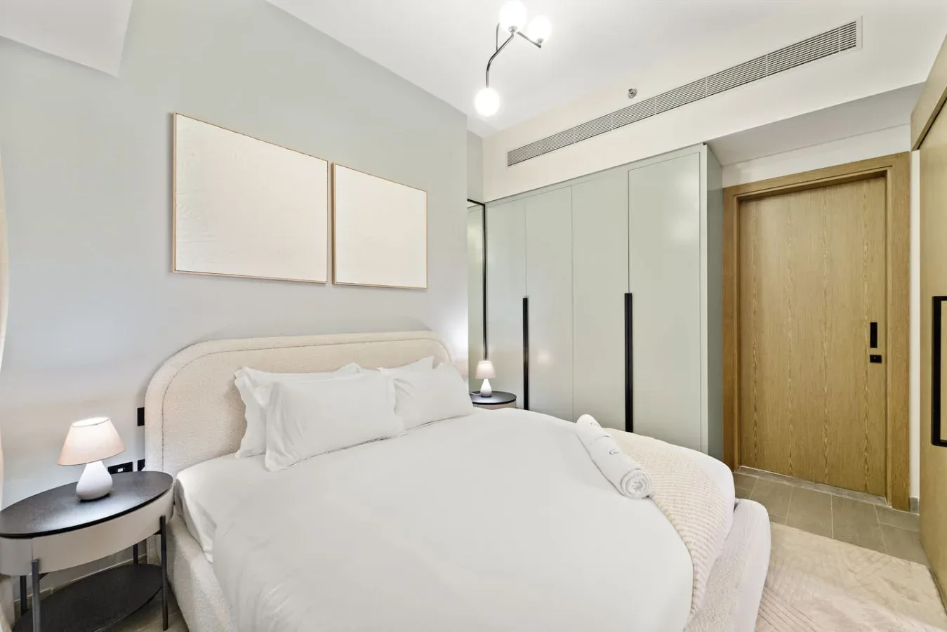 Un dormitorio con una cama bien tendida y armarios empotrados.