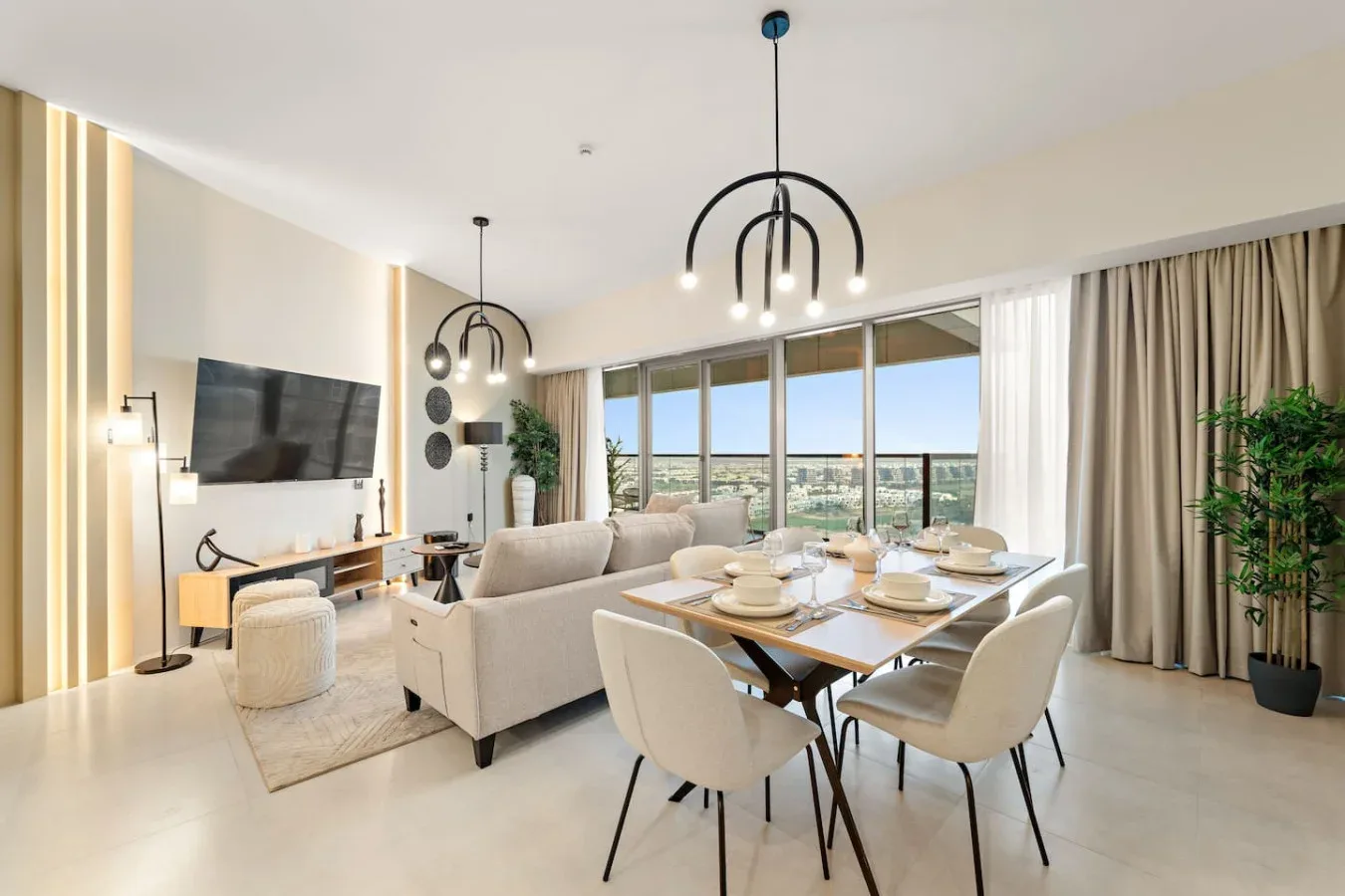 Sala de estar y comedor de planta abierta con asientos, una mesa y grandes ventanales.