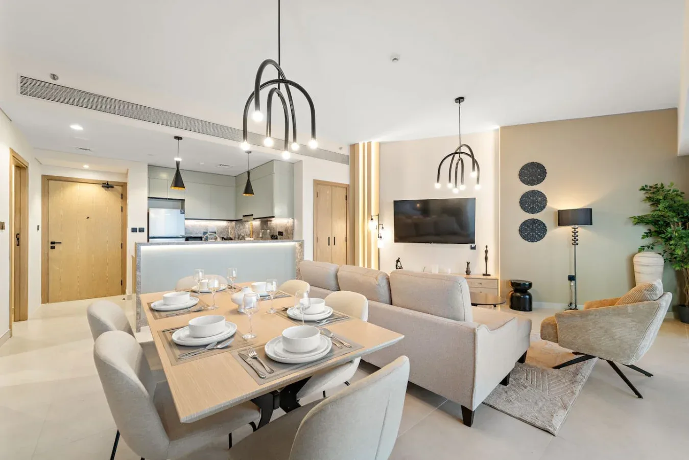 Una sala de estar y comedor de planta abierta con una mesa y un televisor.