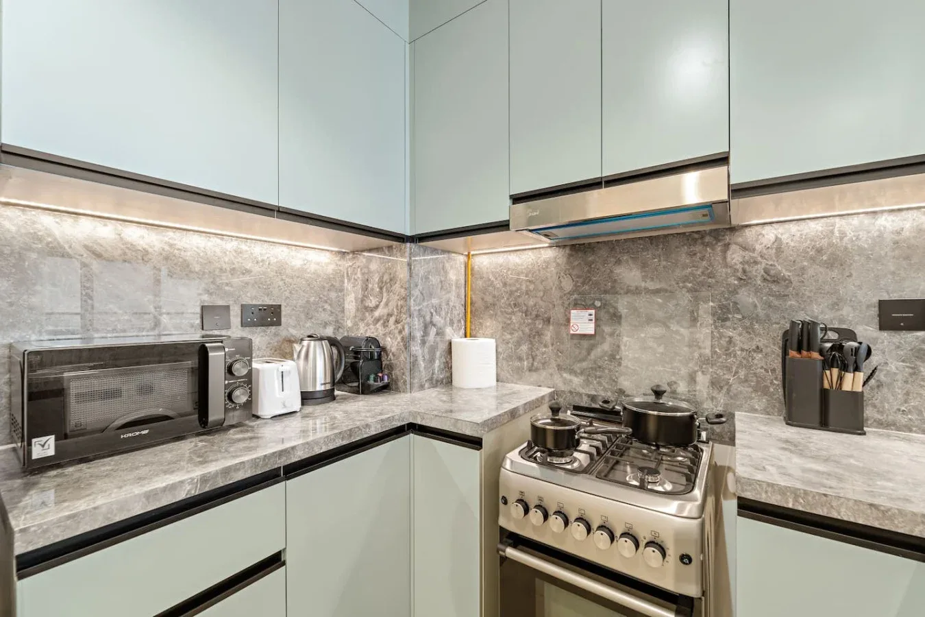 Una cocina moderna con estufa de gas, encimera y gabinetes claros.
