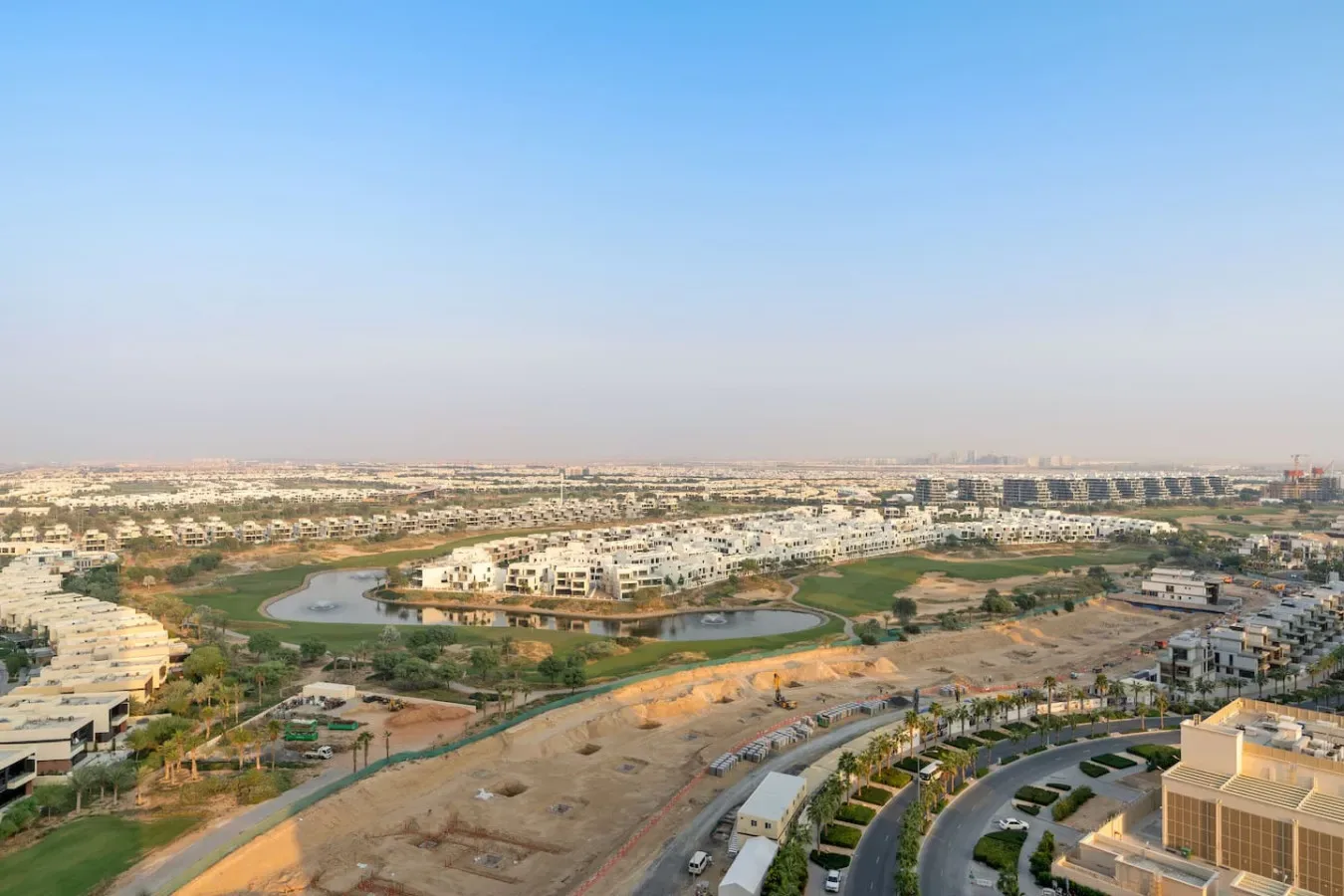 Vista aérea de un desarrollo residencial con caminos curvos y estanques ajardinados.
