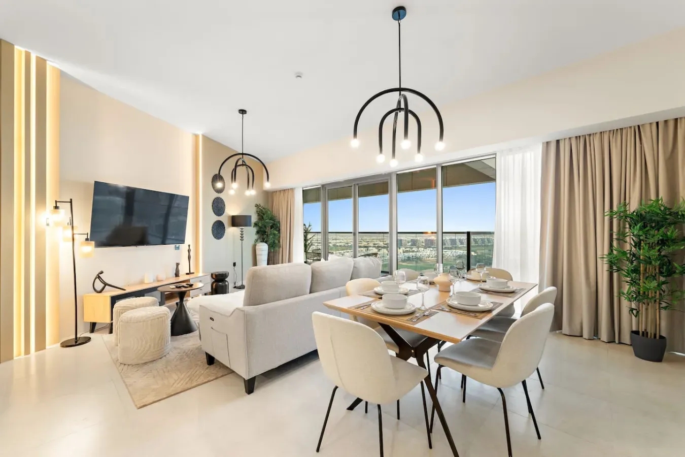 Una luminosa sala de estar y comedor con grandes ventanales y una mesa de comedor.
