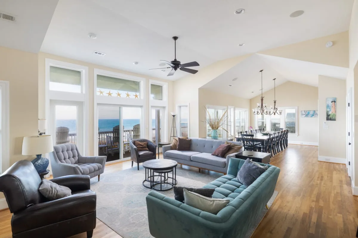 A bright open-plan living and dining room with seating and large windows.