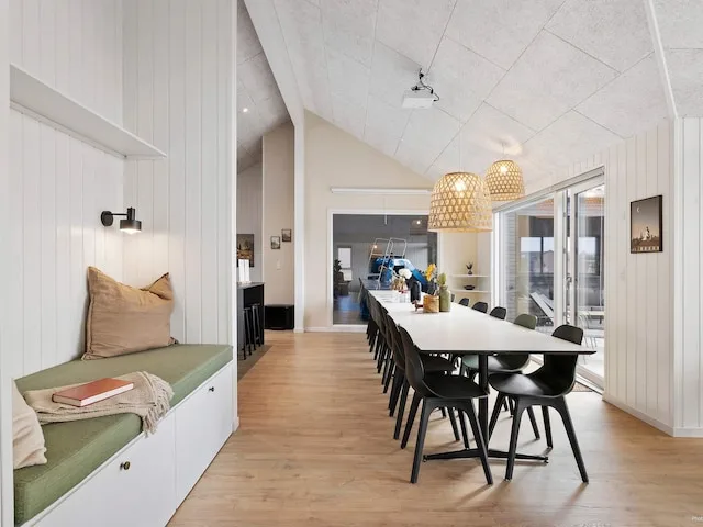 A bright dining area with a long table and bench seating.