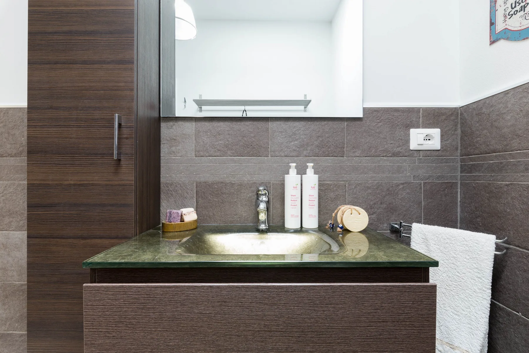 A bathroom vanity with a sink, mirror, and towel.