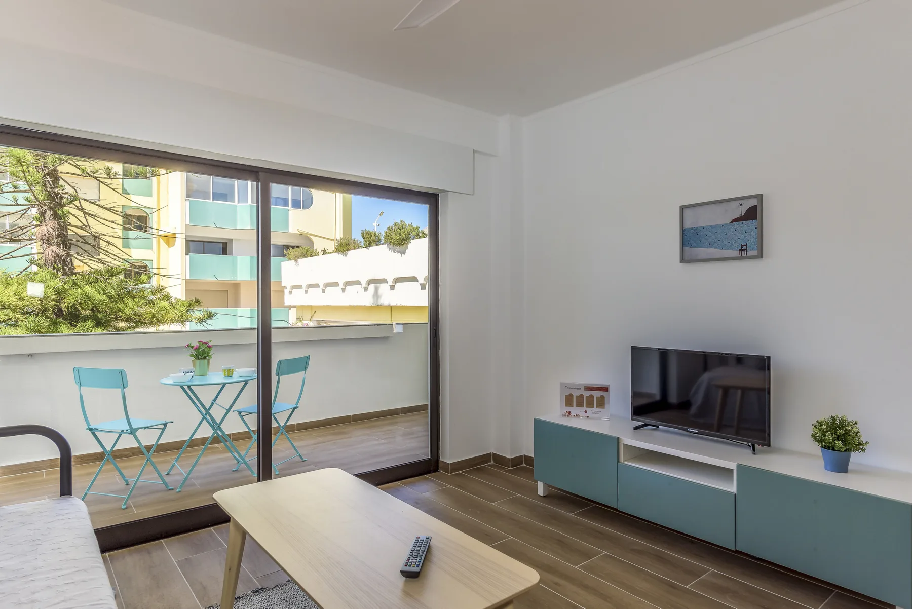 Living room with a television and sliding glass doors opening onto a balcony.