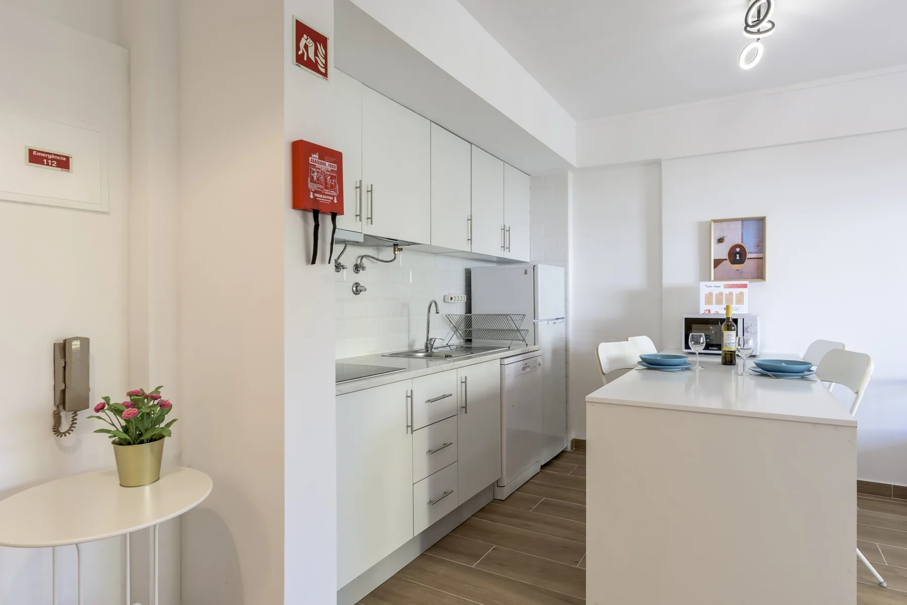 A bright kitchen with white cabinets and a dining table.