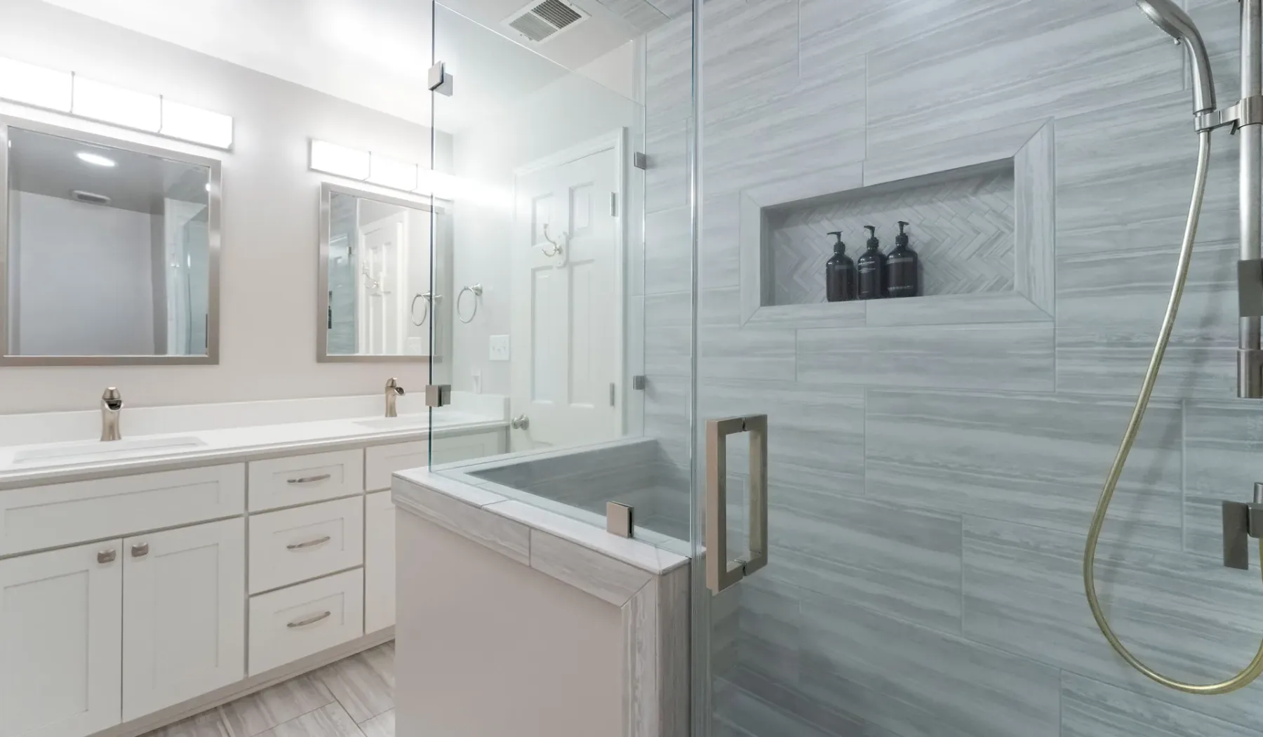 Un baño luminoso con tocador, bañera y ducha con mampara de vidrio.