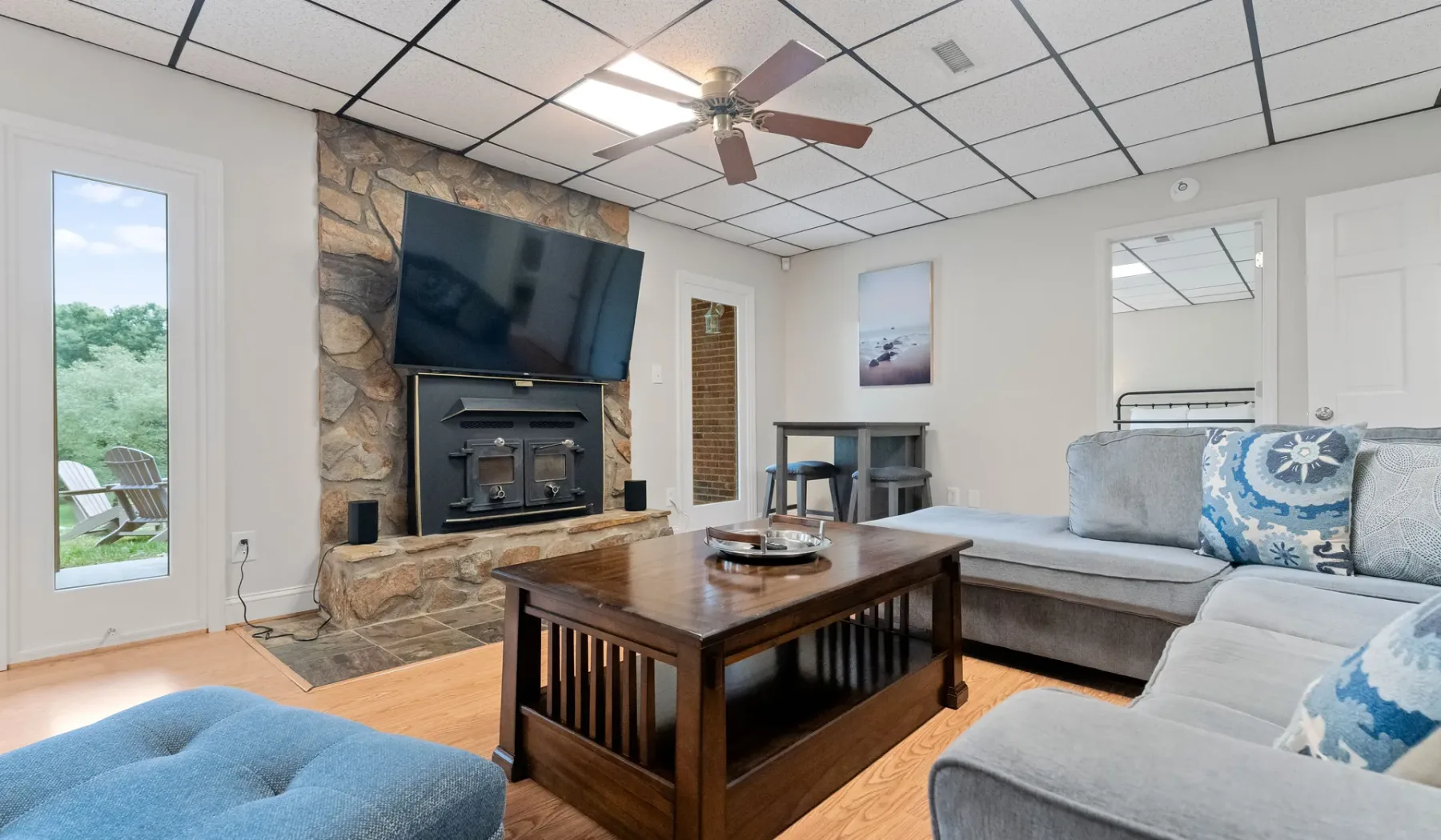 Una sala de estar con chimenea de piedra, televisor y asientos alrededor de una mesa de centro.