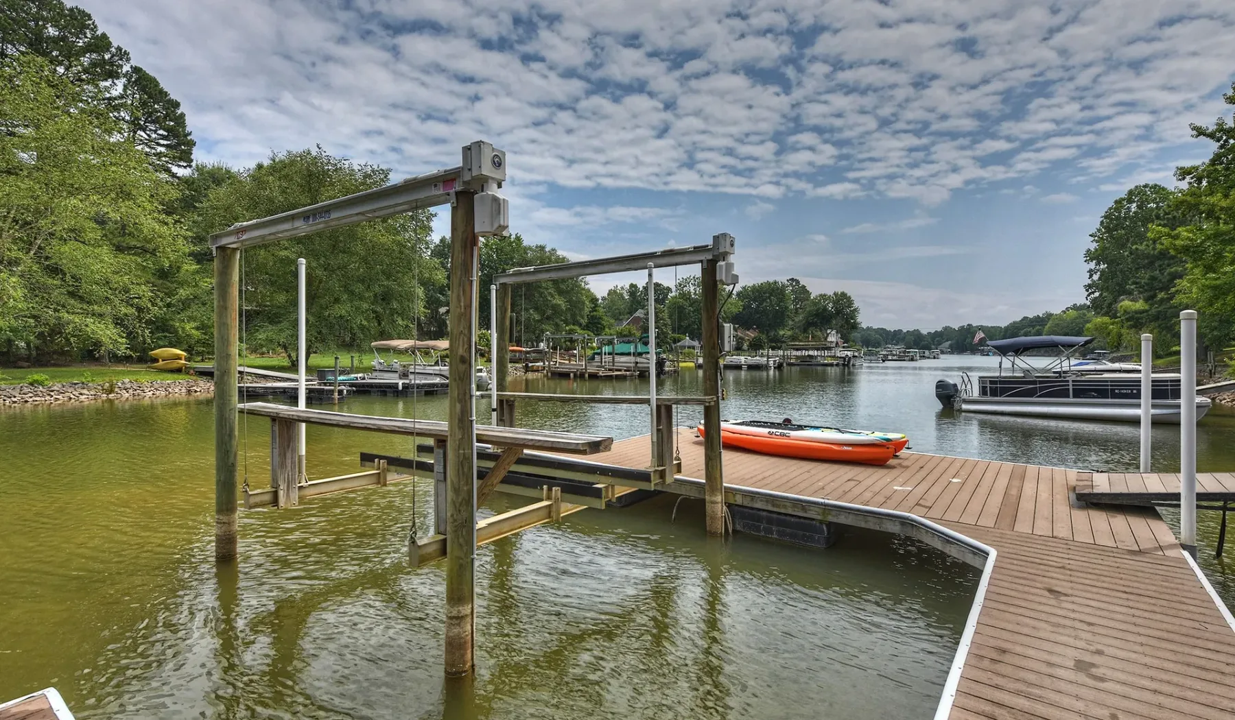 Un muelle de madera se extiende sobre aguas tranquilas, con una pequeña embarcación cerca.