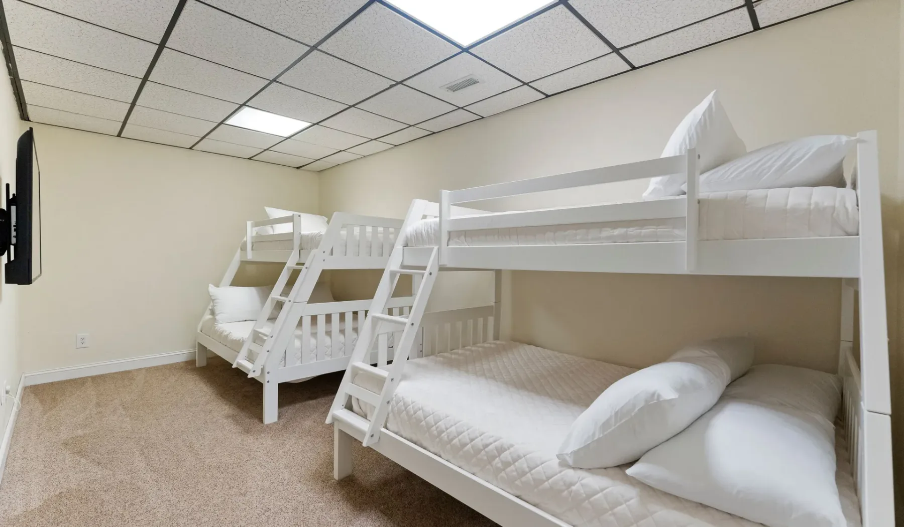 Un dormitorio con dos literas blancas y ropa de cama.