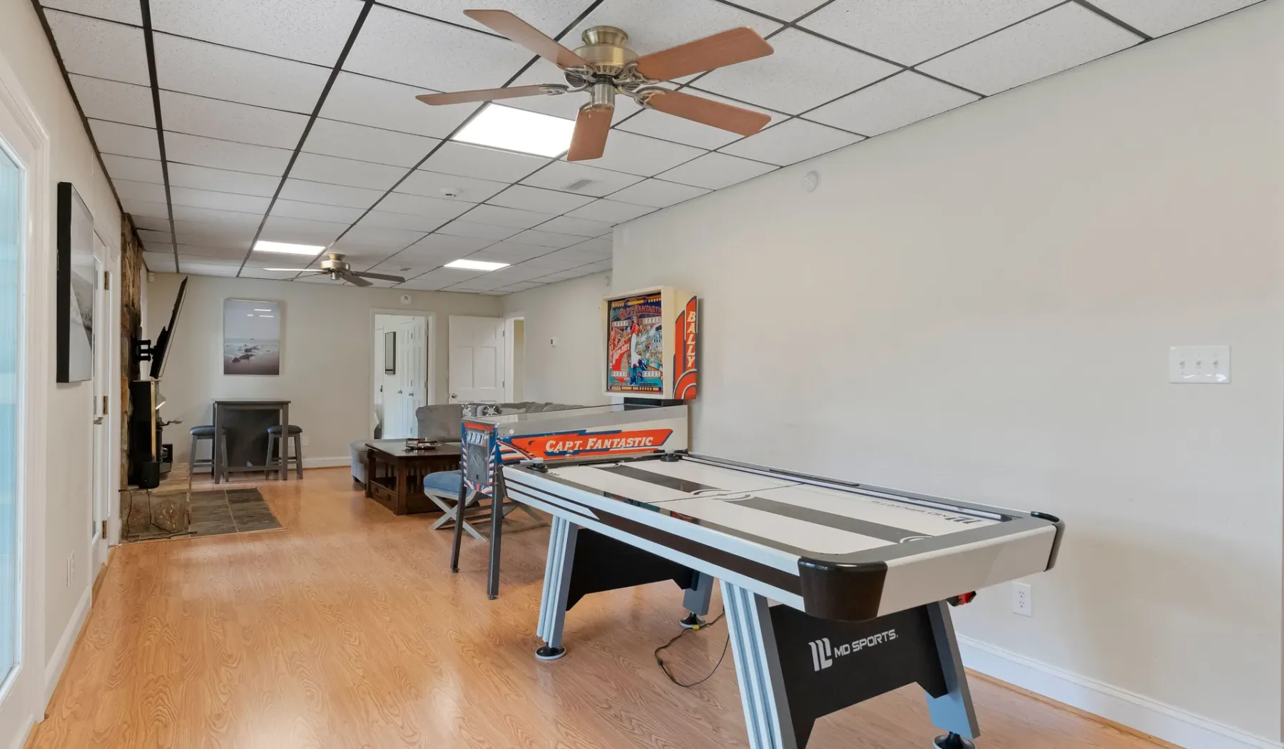 Una sala recreativa con una mesa de shuffleboard y asientos.
