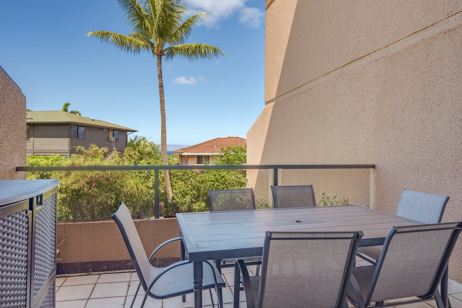 Outdoor dining area on a balcony with a table and seating.