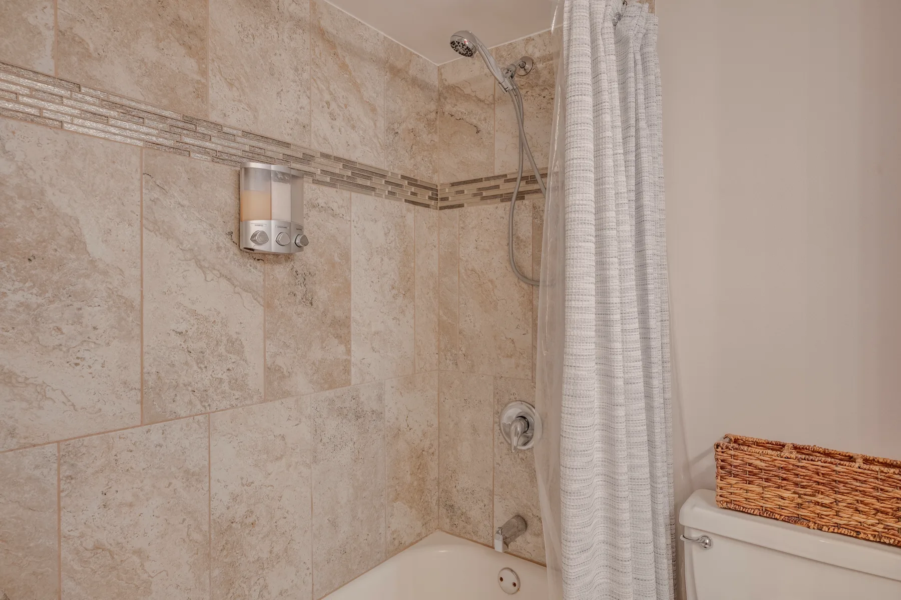 A tiled bathroom with a bathtub and shower curtain.