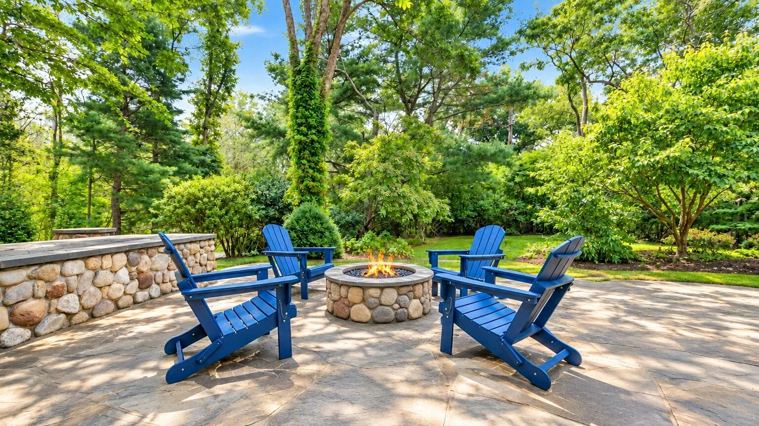 An outdoor seating area with blue chairs arranged around a stone fire pit.