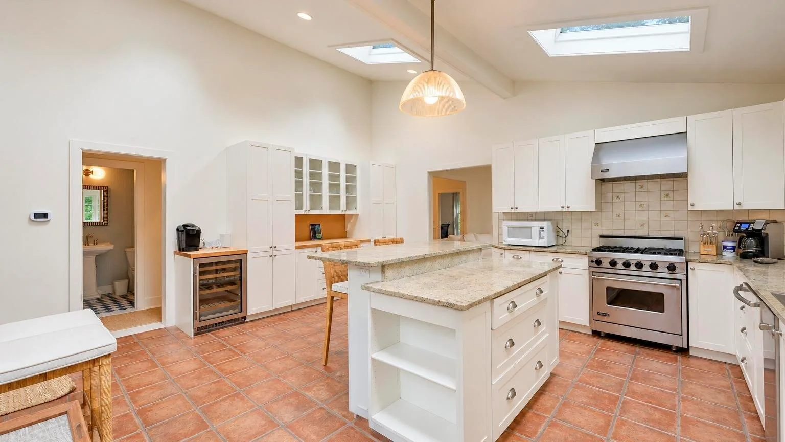 A bright kitchen with white cabinetry and a central island.