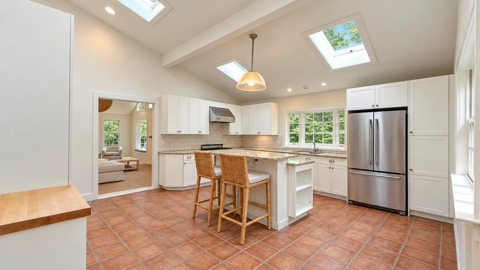 A bright kitchen with a central island, bar seating, and skylights.