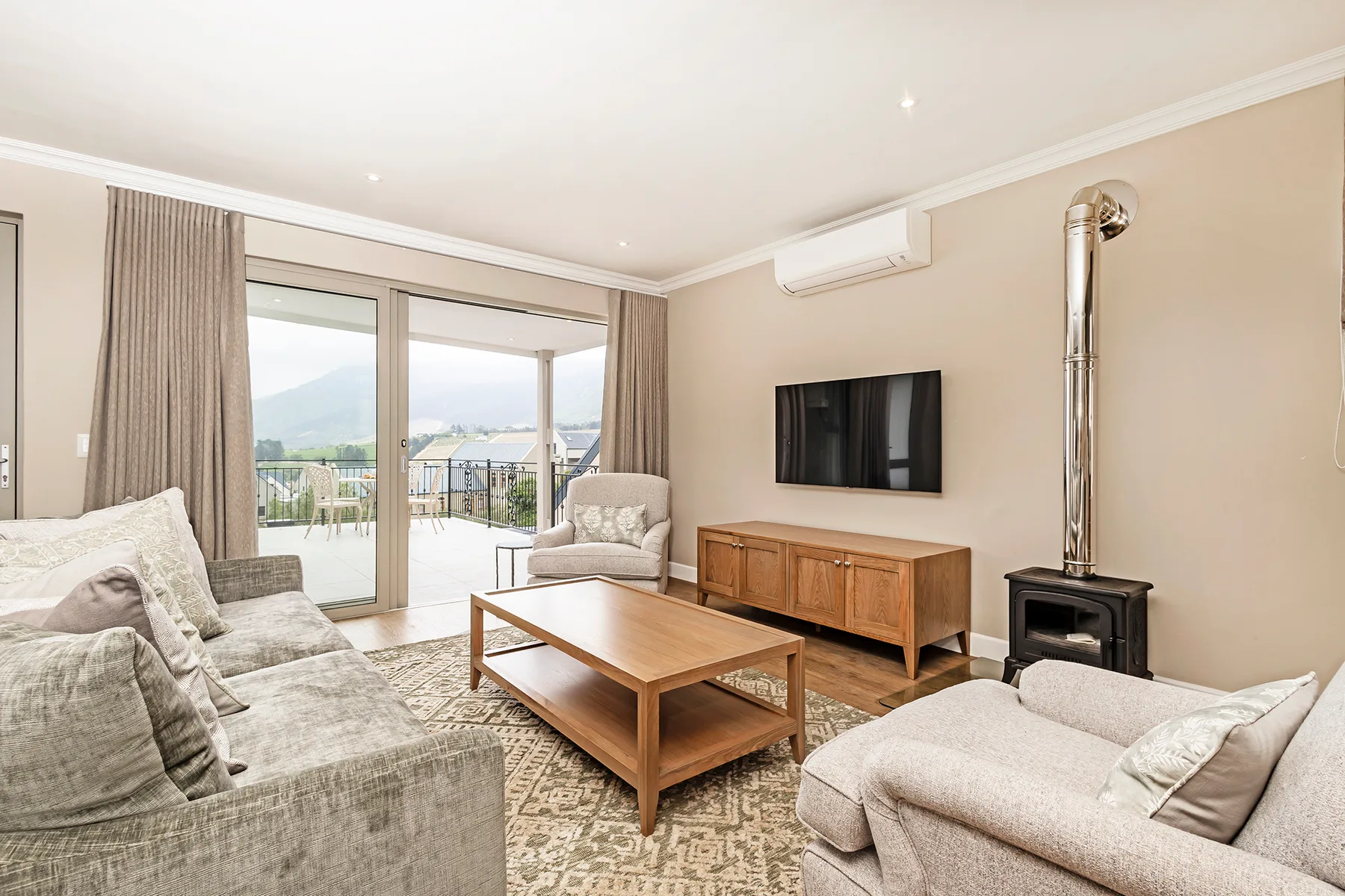 A living room with seating, a coffee table, and sliding glass doors opening to a balcony.