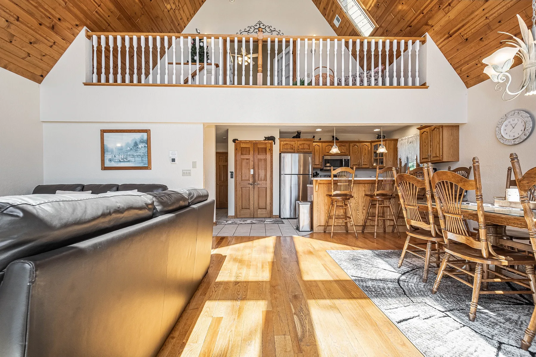 An open living and dining area with a kitchen and wooden ceiling.