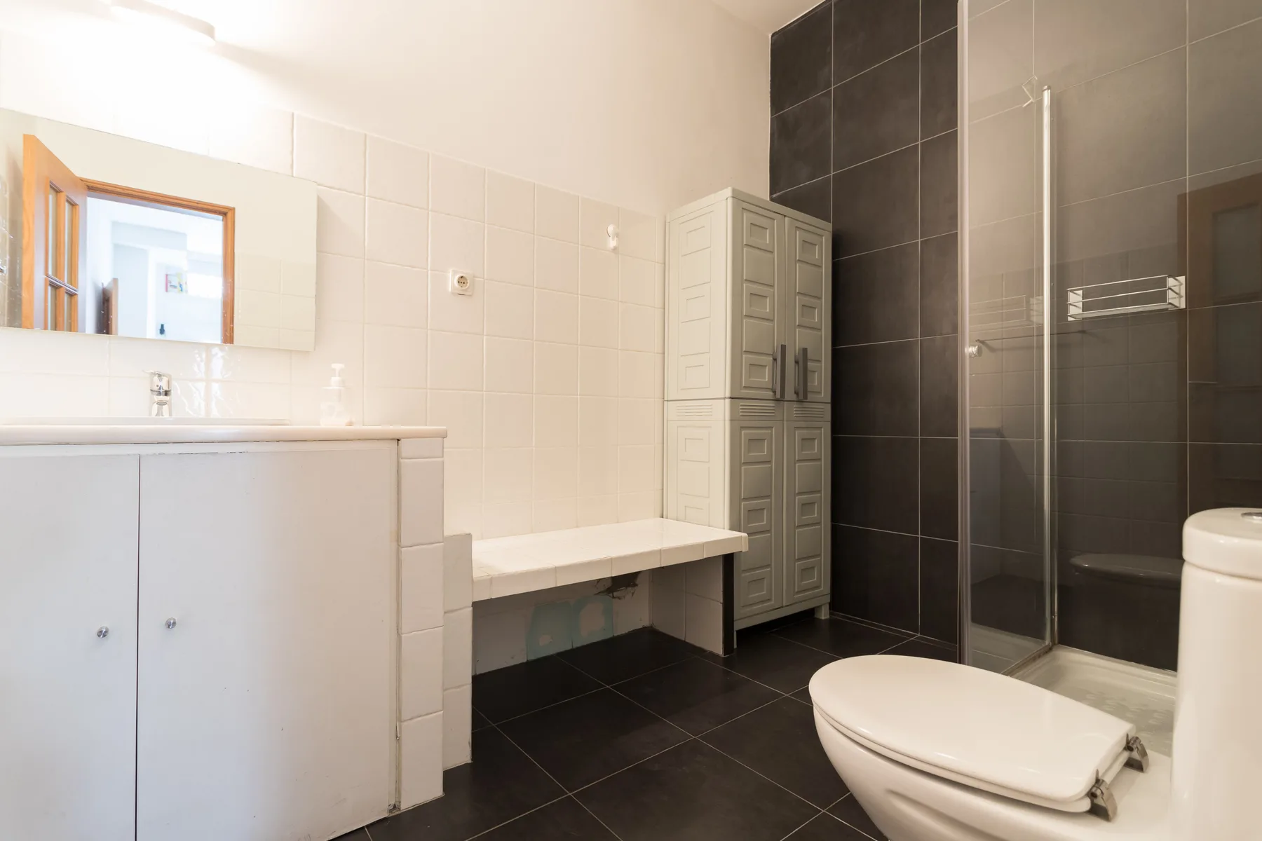 Un baño con lavabo, inodoro y ducha de cristal.