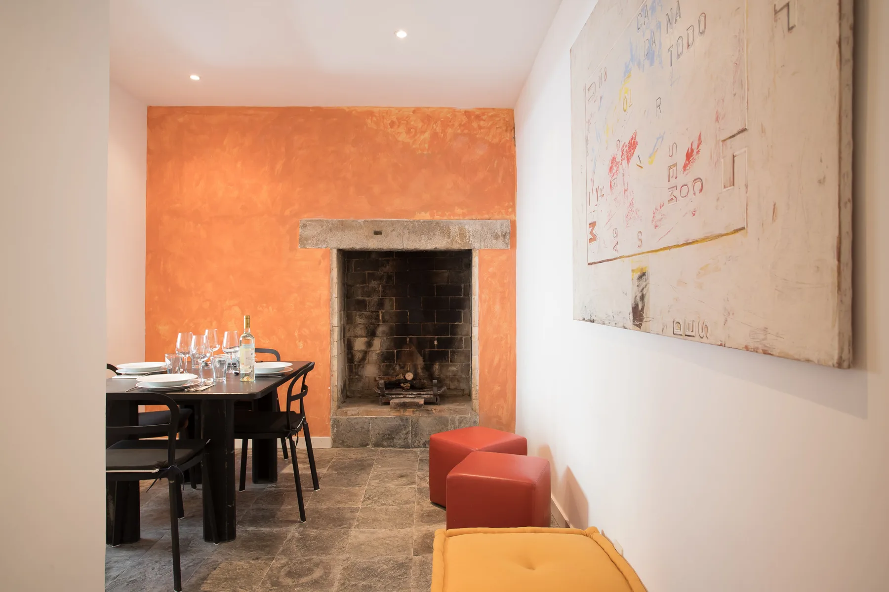 Comedor con una mesa y asientos junto a una chimenea.